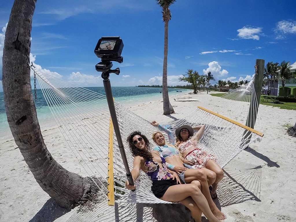 mulheres sentadas em rede fotgrafando com uma GoPro