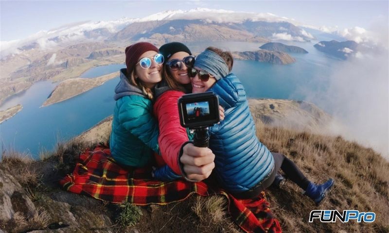 3 mulheres no alto da montanha com uma GoPro