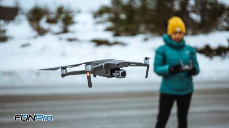 Mulher voando com drone em lugar com neve