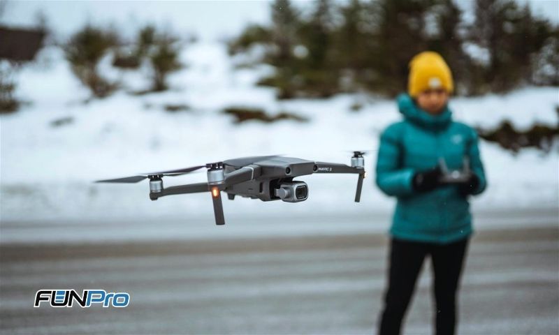 Mulher voando com drone em lugar com neve