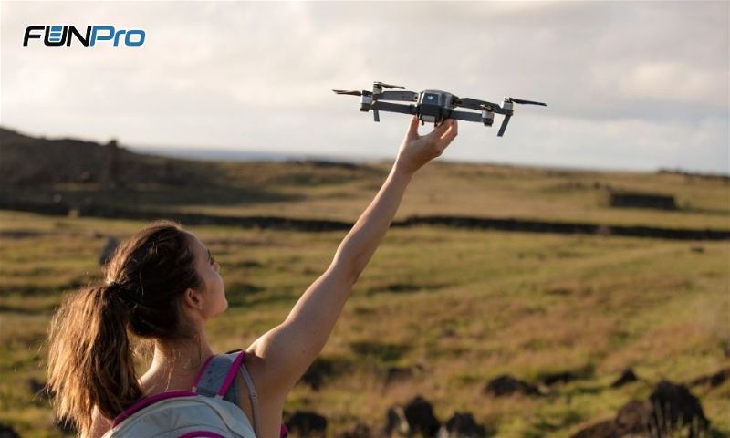 moça segurando drone na mão direita