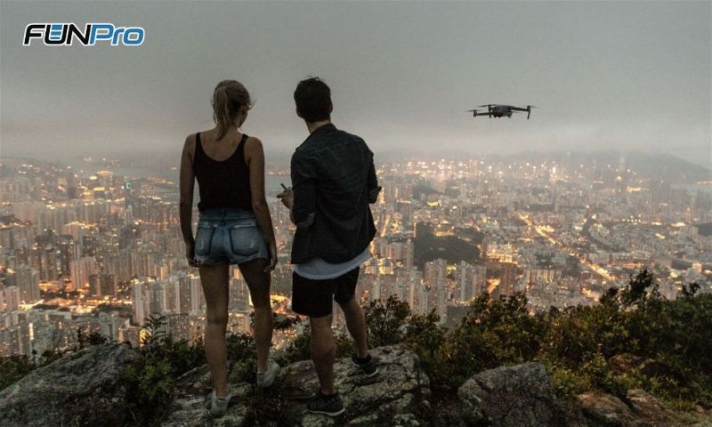casal voando com drone sobre a cidade