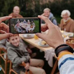 Pessoa tirando foto de uma família no almoço