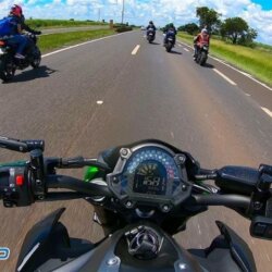 Imagem do capacete de uma moto com vários motociclistas na estrada
