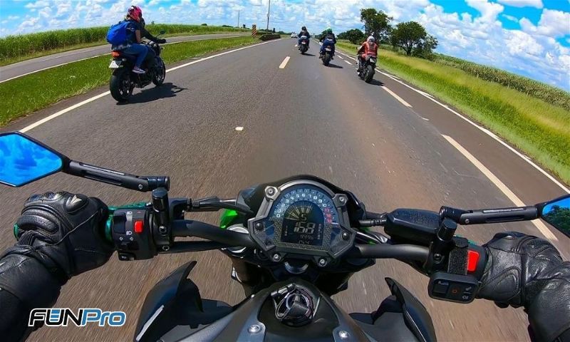 Imagem do capacete de uma moto com vários motociclistas na estrada