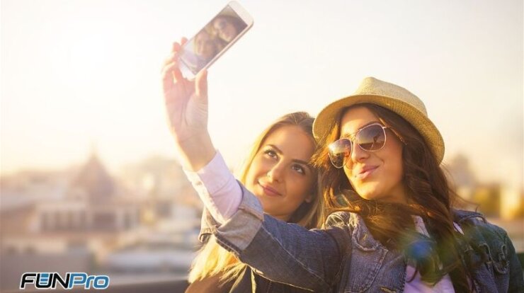 duas amigas tirando selfie com fundo muito iluminado